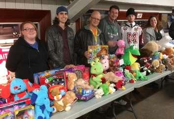 Representatives from Blackburn Radio and the Chatham Goodfellows collect toys for the "No Child Without a Christmas Campaign" during the Chatham Maroons' annual Teddy Bear Toss game Sunday night. (Photo by Tom Heath)