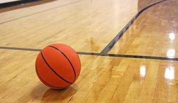 A basketball on a hardwood court. © Can Stock Photo / BLewis