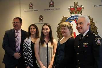 Chatham-Kent mayor Darrin Caniff, left, Const. Rene Cowell and police chief Gary Conn, right,  stand for a photo with  scholarship winners Kayla Coates and Abby Thompson on Tuesday.  
