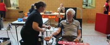 Paul Van Hardeveld rolls up his sleeve and donates blood for the 200th time. june 13, 2018. (Photo by Greg Higgins)