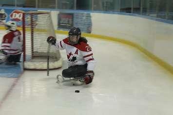 Chatham native Ashley Goure clears the puck from behind the net in a sledge hockey tournament. (Photo courtesy Ashley Gore) 