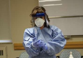 Windsor Regional Hospital employee demonstrates how to put on personal protective equipment for infectious disease control. (Photo by Maureen Revait) 
