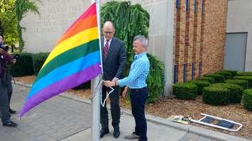 Windsor Mayor Drew Dilkens prepares to raise the rainbow flag at City Hall with David Lenz of Windsor PrideFest on August 9, 2017. Photo by Mark Brown/Blackburn News.