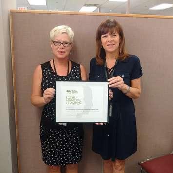 Chantal Perry, Program Manager with ESS and Valerie Colasanti, Chatham-Kent Director of Employment and Social Services, are seen with the Ontario Municipal Social Services Local Municipal Champion award. June 22, 2017. (Photo courtesy of Municipality of Chatham-Kent)