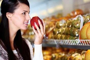 A woman smells an apple. File photo courtesy of © Can Stock Photo / pressmaster