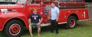 Brent DeNure (left) and Keith Chinnery (right) pose by one of the many classic fire trucks to be featured in the seventh and final Firefest later this month. September 6, 2018. (Photo by Greg Higgins)