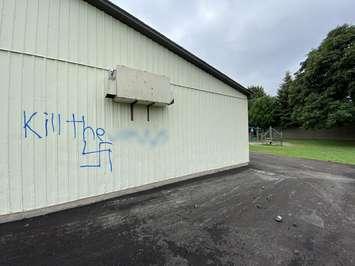 Graffiti that was spray-painted on the wall at Queen Elizabeth II Public School in Chatham. (Photo by Millar Hill)