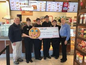 Thamesville Tim Hortons employees present Allan Davies with the Chatham-Kent School Nutrition Program a cheque from their Smile Cookie campaign. Photo provided. 
