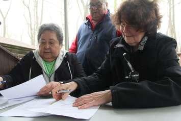 Chief Denise Stonefish, left, signs the land transfer agreement with the United Church of Canada on Friday. (Photo by Michael Hugall)