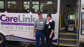 Volunteer drivers Bill Tellier and Tracey Woelk  pose in front of one of the new CareLink buses.