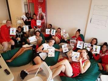 Members of Canada's Senior Women's National Team pose with photos sent to them by MC Hoops campers from Chatham, August 7, 2016 (Photo courtesy of Linda Corrente)