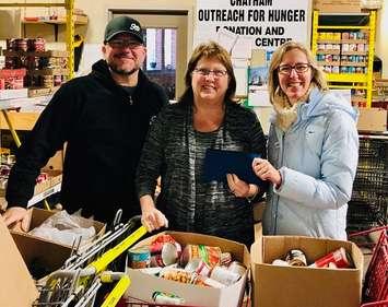 Doug Hunter (L) owner, Sons of Kent Brewing Company, Cindy Parry (M) from Outreach for Hunger and Alysson Storey, organizer of Holiday Jam for Hunger, with the financial donation to Chatham Outreach for Hunger. (Photo courtesy of Alysson Storey)