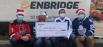 Enbridge employees, JP Lemieux, Angela Scott and Brian Cox, present a cheque to Chatham Goodfellows president Tim Haskell. (Photo submitted but the Chatham Goodfellows)