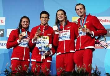 Team Canada swimmers Kylie Masse (from left), Richard Funk, Peggy Oleksiak and Yuri Kisil celebrate their bronze medals at the FINA World Championships in Hungary on July 26, 2017 (Photo courtesy Swimming Canada/Twitter)