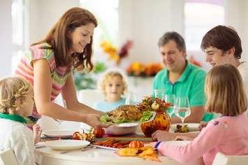 A family gathers for dinner. File photo courtesy of © Can Stock Photo / famveldman