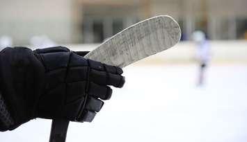 Ice hockey stick in the hand of a player. © Can Stock Photo / SergeyKuznecov