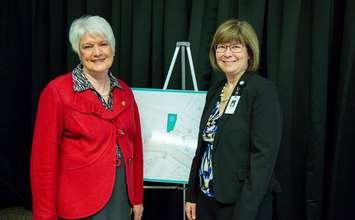 Lori Marshall posing with Liz Sandals in front of display for Replacement Power Plant Project at announcement for funding at Chatham-Kent Health Alliance Wallaceburg site. (Photo provided by Richard Barry). 