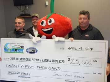 Jaymie Waddick (R) and Ian Waddick (left, representing Mark Waddick) of Waddick fuels present a cheque representing the $25,000 in fuel the company is donating to fuel the International Plowing Match and Rural Expo 2018. Match Mascot Tobe Cobe Jr and Match Co-Chair Leon Leclair accepted the donation,  April 19 2018.  (Photo courtesy of the IPM and RE Media Committee)